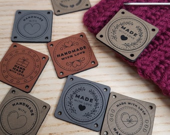 May include: Assortment of eight brown and gray square leather labels with different designs and text. The labels have holes in the corners and say "Handmade with Love", "Hand Made with Love", and "Made with Love".