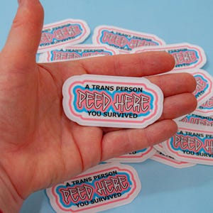 Une personne trans a fait pipi ici. Vous avez survécu. Autocollant. Bord facile à décoller. Jeu de 15 ou 30 points.