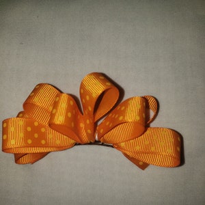 Hair bow. Orange and yellow polka-dot 4 inch grosgrain ribbon loopy hair bow on small french barrette.