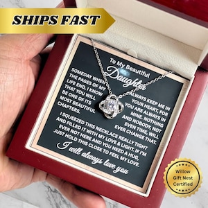 Op de afbeelding: Een zilveren ketting met een sprankelende hanger, gepresenteerd in een rode doos. De doos bevat een kaart met de tekst "To My Beautiful Daughter" en een liefdevolle boodschap. De tekst "I will always love you" is ook zichtbaar.