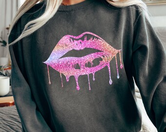 Könnte beinhalten: Ein dunkelgrauer Pullover mit einem pinkfarbenen Glitzerlippen-Motiv. Die Lippen tropfen mit Glitzer.