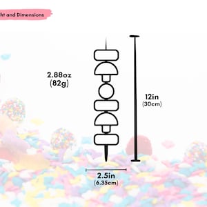 Pu&ograve; includere: Un disegno a tratto nero e bianco di uno spiedino decorativo. Lo spiedino &egrave; lungo 30 cm e largo 6,35 cm e pesa 82 g. Lo spiedino presenta una serie di forme geometriche.