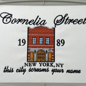 May include: Embroidered design featuring a brick building with a sign that reads "Cornelia Street 1989" and the text "NEW YORK, NY this city screams your name".