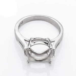 May include: Silver ring setting with a prong setting for an oval shaped gemstone.