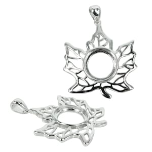 May include: Silver maple leaf pendant with a round bezel for a stone or cameo. The pendant has a delicate, intricate design.