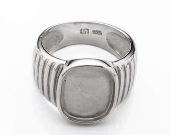 May include: A silver signet ring with a smooth, rectangular top and a textured band. The ring is marked with "925" on the inside.