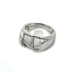 May include: A silver ring with a cut-out design. The ring is marked with "925" and "LI".