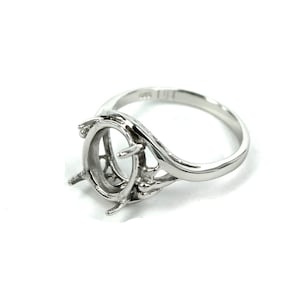 May include: Silver ring with a delicate, openwork design and a large oval setting for a gemstone. The ring is designed to hold a large oval-shaped stone.