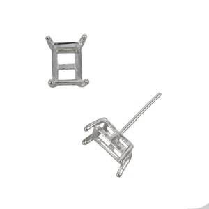 May include: A pair of silver earring settings with a rectangular shape. The settings are designed to hold a gemstone or other embellishment.