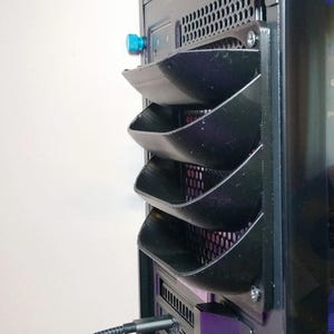 May include: Black computer case featuring a series of angled vents. The vents are stacked vertically and have a curved design. A blue knob is visible near the top. The case has a mesh panel and a cable plugged into the bottom.