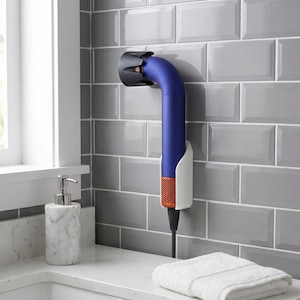 May include: A blue and orange hair dryer mounted on a gray tiled wall. The hair dryer is held in a white holder. A white towel rests on the counter below. A marble soap dispenser is also on the counter.
