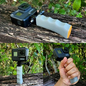 Può includere: Videocamera d'azione nera con impugnatura grigia e arancione. La fotocamera è montata sull'impugnatura, progettata per l'uso manuale. L'impugnatura ha una superficie strutturata per una presa sicura. La fotocamera è mostrata in più viste.