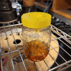 a glass jar with a yellow lid sitting on a rack