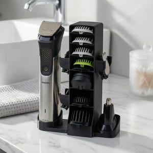 以下が含まれることがあります： シルバーと黒のフィリップスのマルチグルーマーセット。さまざまなトリミングアタッチメントが付属しています。セットには、メインのグルーミングデバイス、収納ユニット、白と緑のいくつかのコームアタッチメントが含まれています。デバイスは白い大理石の表面にあります。