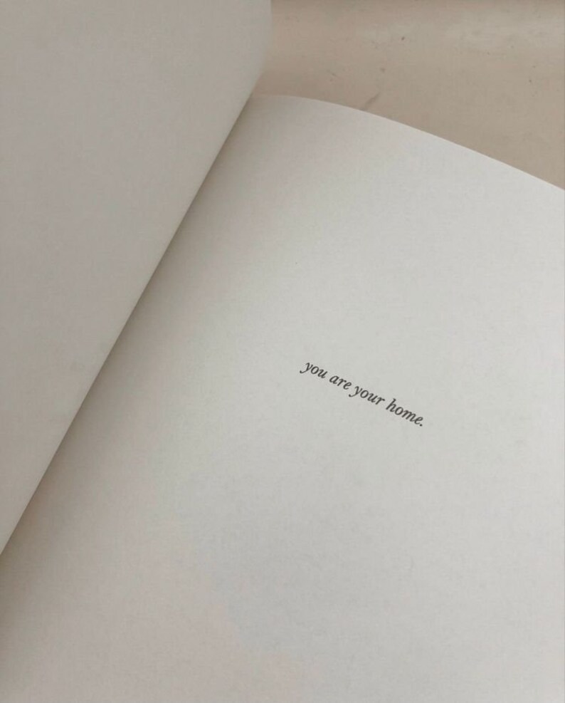 May include: An open book with the text "you are your home" written on a white page.