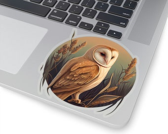 May include: A round sticker featuring a detailed illustration of a barn owl with brown and white feathers, set against a backdrop of tall grass and a warm, golden sky. The owl is winking. The sticker is on a laptop.