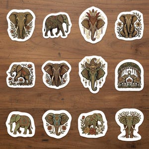 May include: A collection of twelve decorative elephant stickers. Each sticker features a detailed illustration of an elephant in various poses and designs, with floral and ornamental accents. The stickers are on a wooden surface.