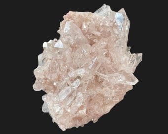 May include: A cluster of clear quartz crystals with a pale pink hue. The crystals are clustered together, with sharp, pointed tips. The overall shape is irregular and textured, set against a black background.