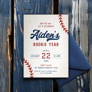 Może przedstawiać: Zaproszenie w tematyce baseballu z napisem "Aiden's Rookie Year". Zaproszenie posiada wzór szwu baseballowego i granatową kopertę. Data to 22 kwietnia 2024 r., godzina 12-16. Miejsce imprezy to 123 Address Road NY 11234.