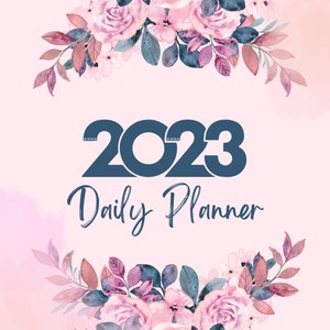 Op de afbeelding: 2023 Dagplanner met een bloemmotief. De omslag heeft een lichtroze achtergrond met roze en paarse rozen en bladeren in aquarel. Het jaar 2023 staat in een donkerblauwe letter, met daaronder de woorden "Daily Planner".