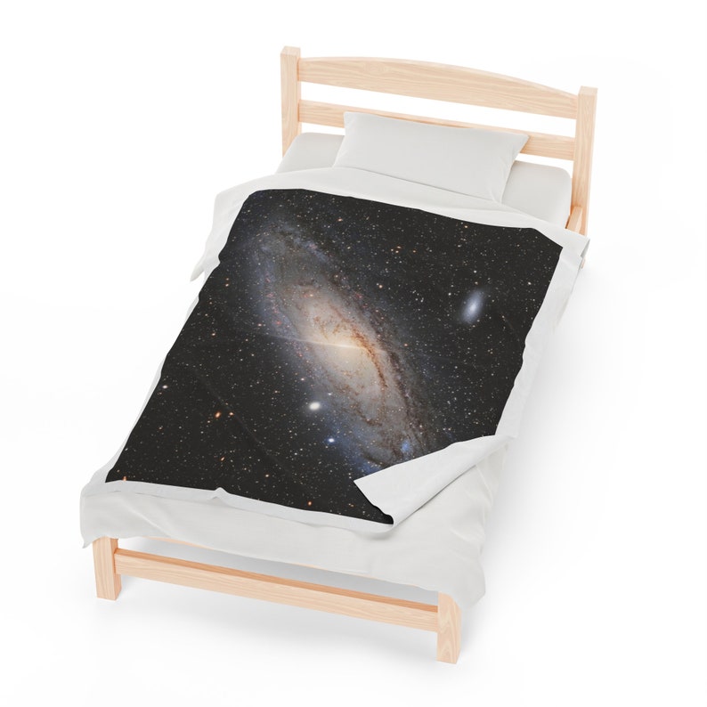 Pu&ograve; includere: Un letto singolo bianco con una struttura in legno e un piumino bianco. Il piumino ha una stampa in bianco e nero di una galassia con una nebulosa a spirale.