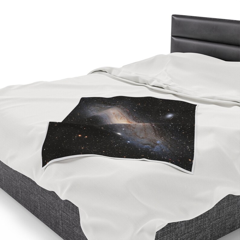 Pu&ograve; includere: Un letto bianco con una testiera nera e una coperta bianca con una stampa di galassia. La stampa di galassia presenta una nebulosa vorticosa con stelle e uno sfondo scuro.
