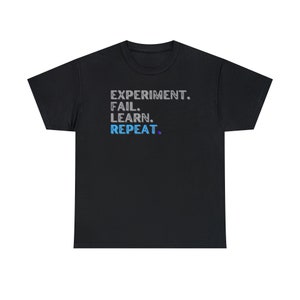 May include: Black t-shirt with the text "EXPERIMENT. FAIL. LEARN. REPEAT." in a gray and blue color scheme.