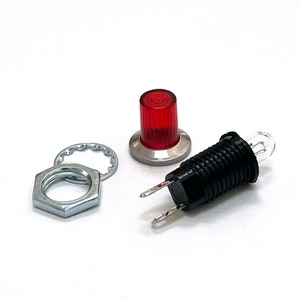 Puede incluir: Una luz LED roja con una lente transparente, un componente eléctrico negro con dos cables, una tuerca plateada y una arandela plateada.