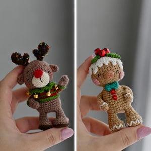 Könnte beinhalten: Zwei gehäkelte Weihnachtsschmuckstücke: ein Rentier und ein Lebkuchenmann. Das Rentier ist braun mit roter Nase, braunem Geweih und einem grün-roten Pullover. Der Lebkuchenmann ist hellbraun mit weißem Zuckerguss, einer grünen Fliege und roten Knöpfen.