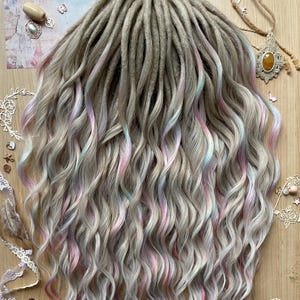 May include: A collection of light grey dreadlocks with pastel pink and blue streaks. The dreadlocks have a wavy texture and are arranged to cascade downwards. The image is taken from above, showing the full length of the dreadlocks.