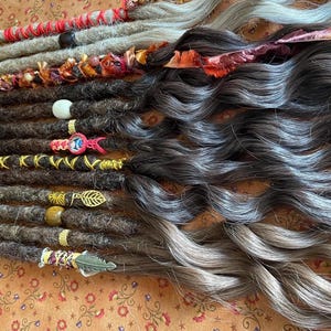 May include: A set of brown and grey synthetic dreadlocks with various beads and charms. The dreadlocks are arranged in a row and are ready to be installed.