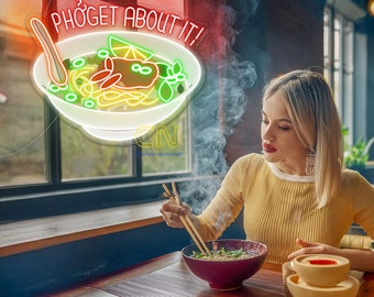 May include: A neon sign with the words "PHO'GET ABOUT IT!" above a bowl of pho. The sign is red and white. A woman is eating pho with chopsticks from a burgundy bowl. There are two small yellow bowls on the table.