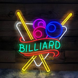 Può includere: Un cartello al neon con la parola "BILLIARD" in lettere verdi su uno stendardo rosso. Due stecche da biliardo gialle e bianche sono incrociate dietro lo stendardo. Tre palle da biliardo colorate sono dietro le stecche.