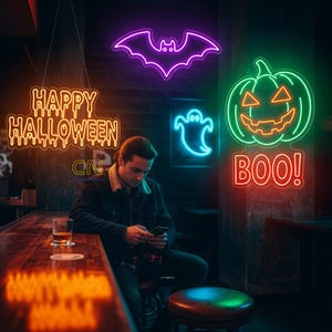 May include: A bar scene with neon Halloween signs. A purple bat, a green jack-o'-lantern with the word "BOO!" in red, a blue ghost, and the words "HAPPY HALLOWEEN" in orange. A person is sitting at the bar.