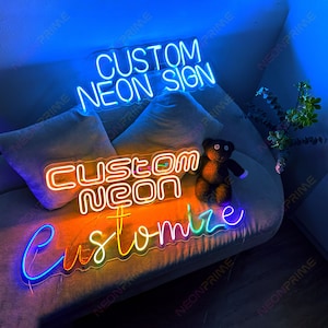 May include: Three neon signs with the text "Custom Neon Sign", "Custom Neon", and "Customize". The signs are lit up in different colors, including blue, orange, yellow, green, and purple. The signs are displayed on a couch with a teddy bear sitting in front of them.