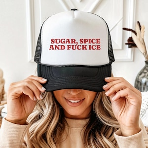 Könnte beinhalten: Eine weiß-schwarze Trucker-Cap mit einem Schaumstoff-Frontpanel, auf dem der rote Text "SUGAR, SPICE AND FUCK ICE" in einer fetten, serifenlosen Schrift gedruckt ist. Die Kappe hat einen schwarzen Schirm und ein schwarzes Netzgewebe.