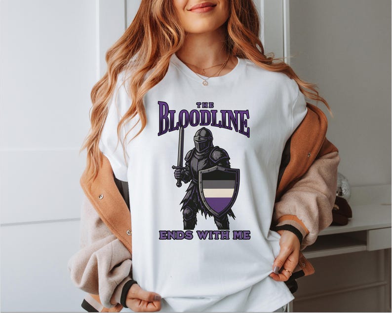 Puede incluir: Camiseta blanca con un gr&aacute;fico de un caballero sosteniendo una espada y un escudo. El escudo es negro, blanco y morado. El texto en la camiseta dice "The Bloodline Ends With Me".