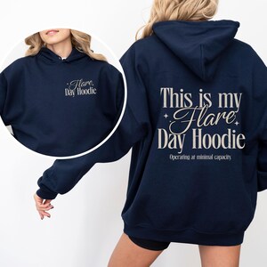 May include: Navy blue hoodie with the text "Flare Day Hoodie" on the front and "This is my Flare Day Hoodie" on the back. The back also includes the text "Operating at minimal capacity."