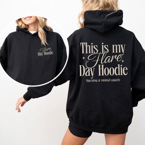 May include: Black hoodie with the text "This is my Flare Day Hoodie" on the back and "Flare Day Hoodie" on the front. The hoodie has a drawstring hood and a relaxed fit. The text "Operating at minimal capacity" is below the main text.