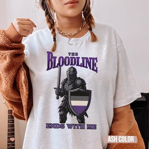 Puede incluir: Camiseta blanca con un gr&aacute;fico de caballero morado y negro y el texto "The Bloodline Ends With Me".