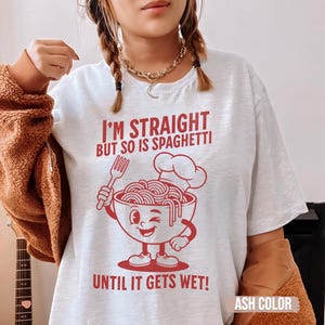 Puede incluir: Camiseta blanca con un gráfico rojo de un tazón de espaguetis con un gorro de chef y el texto "I'm Straight But So Is Spaghetti Until It Gets Wet!"