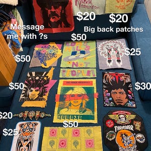 May include: A collection of colorful fabric patches with various designs and prices listed. The patches feature images of an owl, a skull, a Native American headdress, a tiger, a skateboard, and a skull with wings. The patches are arranged on a blue couch.