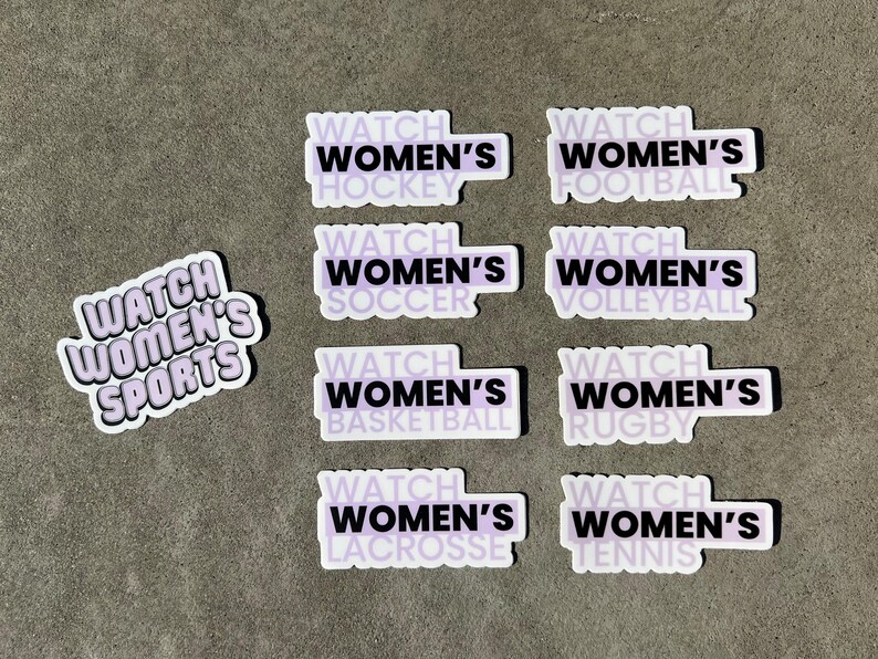 May include: Nine stickers with a purple background and black text. Each sticker says "Watch Women's" followed by a different sport: hockey, soccer, football, volleyball, basketball, rugby, lacrosse, and tennis. One sticker says "Watch Women's Sports".
