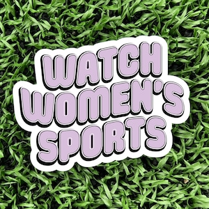 a 3 inch wide vinyl sticker with a purple and black design that reads watch womens sports is displayed on a turf background