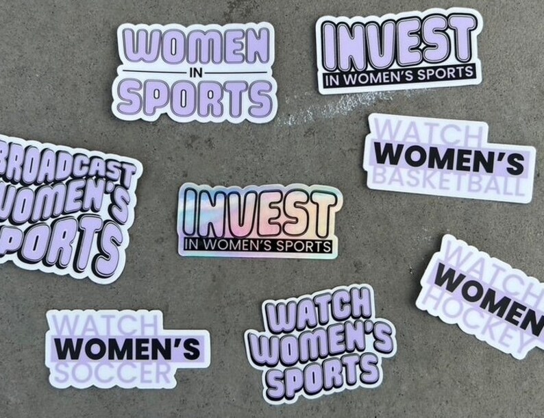 Puede incluir: Una colecci&oacute;n de pegatinas con varios dise&ntilde;os que promueven los deportes femeninos. Las pegatinas incluyen frases como "Invertir en deportes femeninos", "Ver f&uacute;tbol femenino" y "Emitir deportes femeninos".