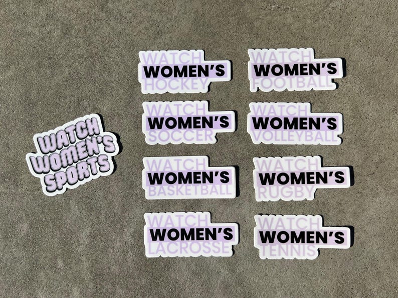 May include: Nine stickers with a purple background and black text. Each sticker says "Watch Women's" followed by a different sport: hockey, soccer, football, volleyball, basketball, rugby, lacrosse, and tennis. One sticker says "Watch Women's Sports".