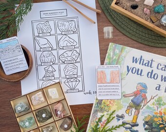 May include: A wooden box with nine compartments filled with different colored rocks. The box is labeled with numbers 1 through 9. A Mohs Hardness Scale chart is visible in the background, along with a book titled "What can you do with a rock?" by Tat Zieltow Miller, illustrated by Katie Kath.