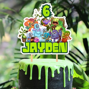 Puede incluir: Un pastel verde y negro con glaseado verde y un adorno de pastel verde y blanco con un personaje de dibujos animados con el texto "JAYDEN" y el número "6". Hay cuatro cupcakes verdes con lunares blancos y glaseado verde con chispas.