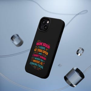 May include: Black phone case featuring the text "MOM BRAIN: I HAVE 47 TABS OPEN AND I DON'T KNOW WHERE THE MUSIC IS COMING FROM" in pink, blue, orange, and green. The case is angled, displaying the design.