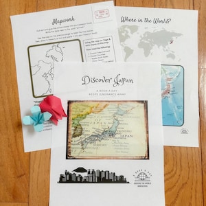 Könnte beinhalten: Lehrmaterialien für ein Homeschooling-Projekt. Das Bild zeigt ausgedruckte Arbeitsblätter mit Karten, darunter eine von Japan. Der Text enthält "Mapwork" und "Where in the World?" Origami und der Text "Discover Japan" sind ebenfalls zu sehen.